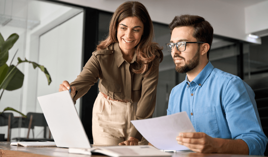 A sales consultant showing a client how to use their solution on the computer